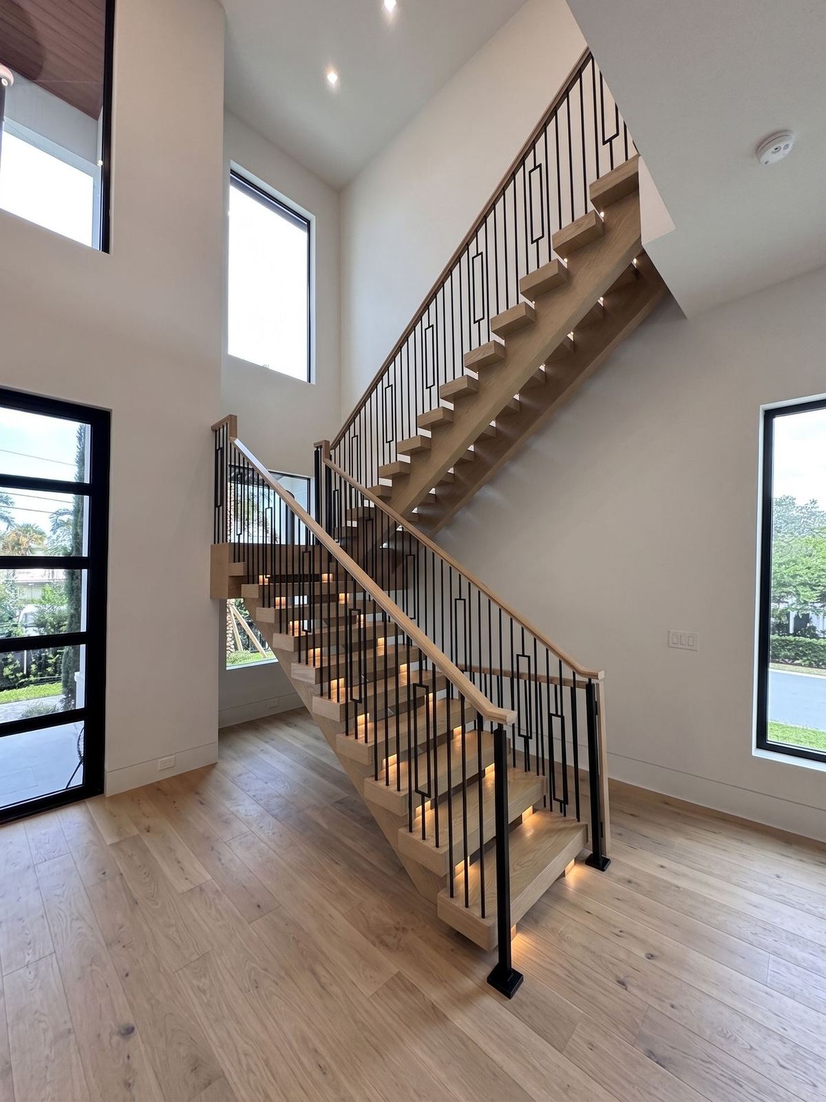Curved custom staircase with wood treads and a slim metal handrail